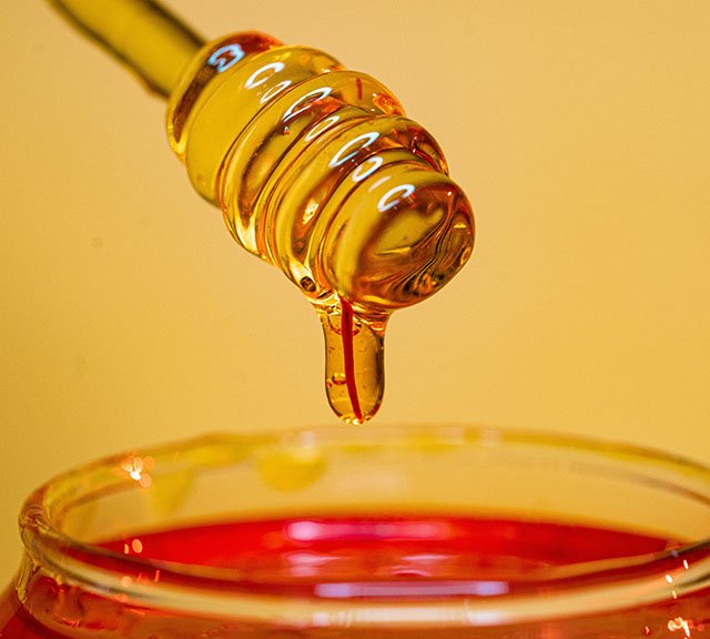 honey drizzling from a honey dipper